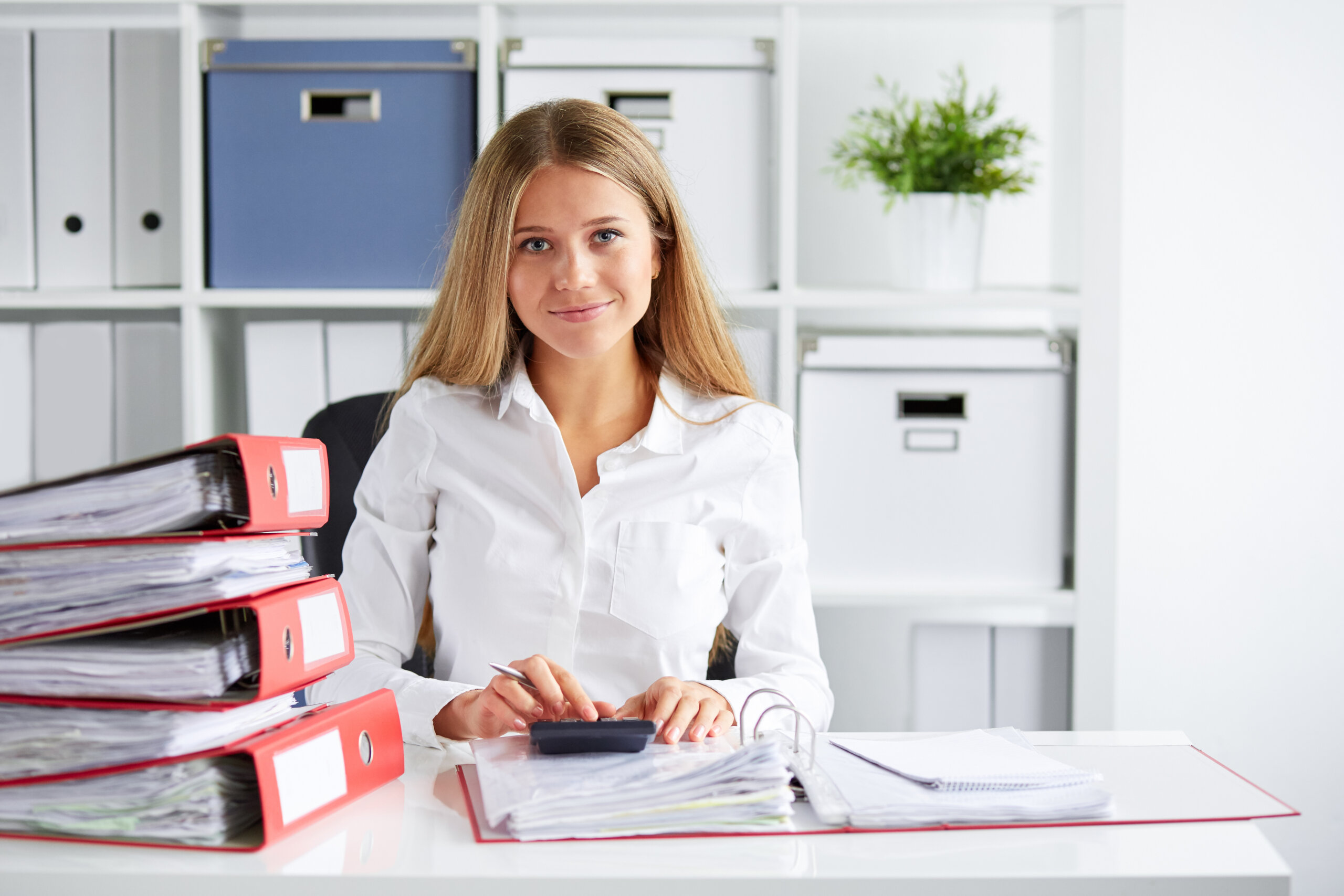 Smiling,Business,Woman,Calculates,Tax,At,Desk,In,Office