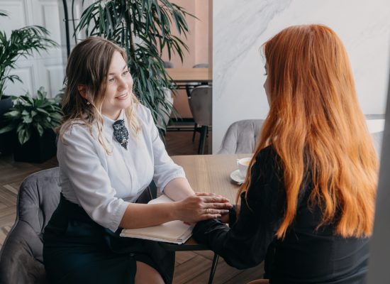 Empathy, friendly support, each other's support and sisterhood. Young woman comforting her friend sitting in cafe. Female Psychotherapist supporting her depressed patient