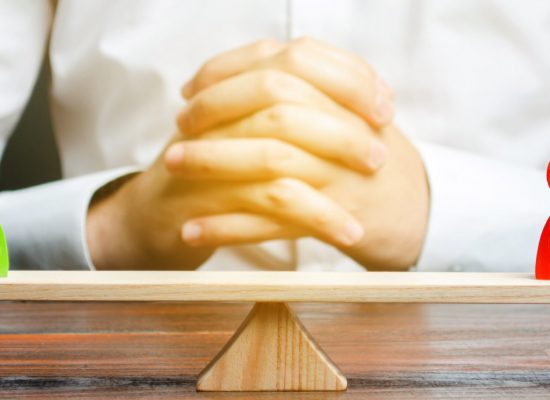 A man with hands in the lock and looks at the scales with green and red figures. Disagreement and misunderstanding, establishing contact. Agreements. Conflict resolution and search for a compromise.