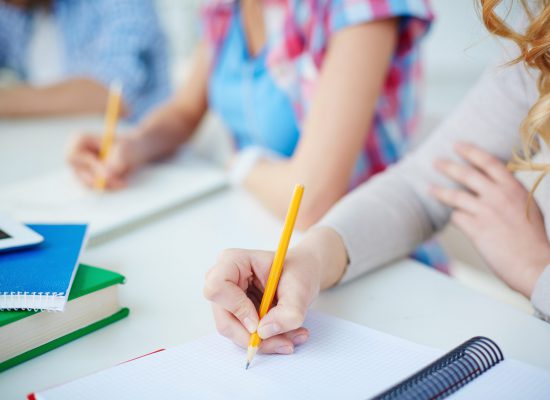 Several groupmates carrying out written task or writing lecture
